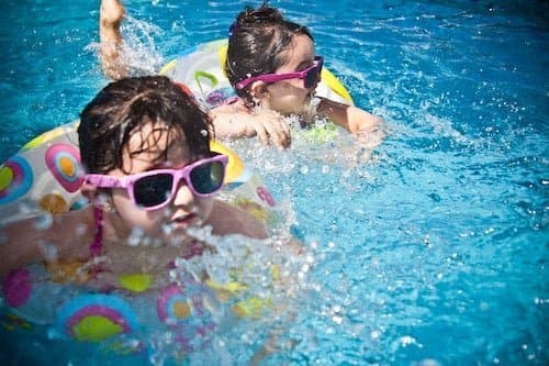 Children playing in a swimming pool in summer