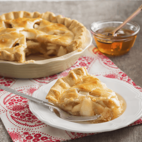 Apple pie served with a bowl of honey