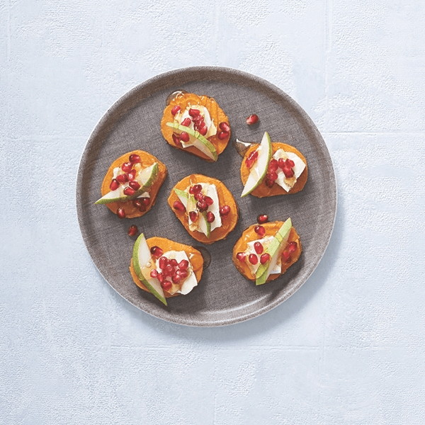 Sweet potato rounds topped with pomegranates, pear and goat cheese