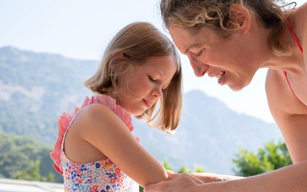 An adult tending to a child's arm outdoors