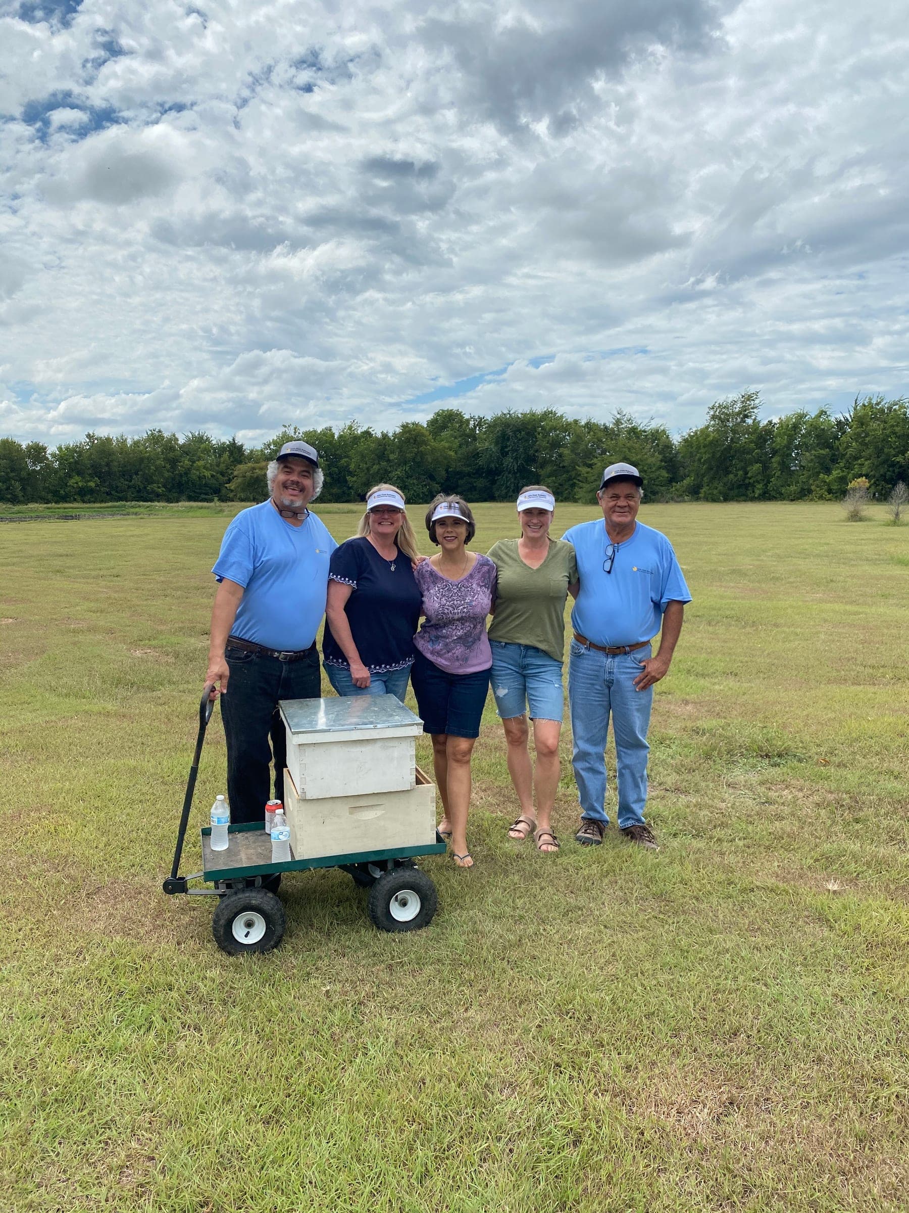 The crew with a cart of hive boxes in a field