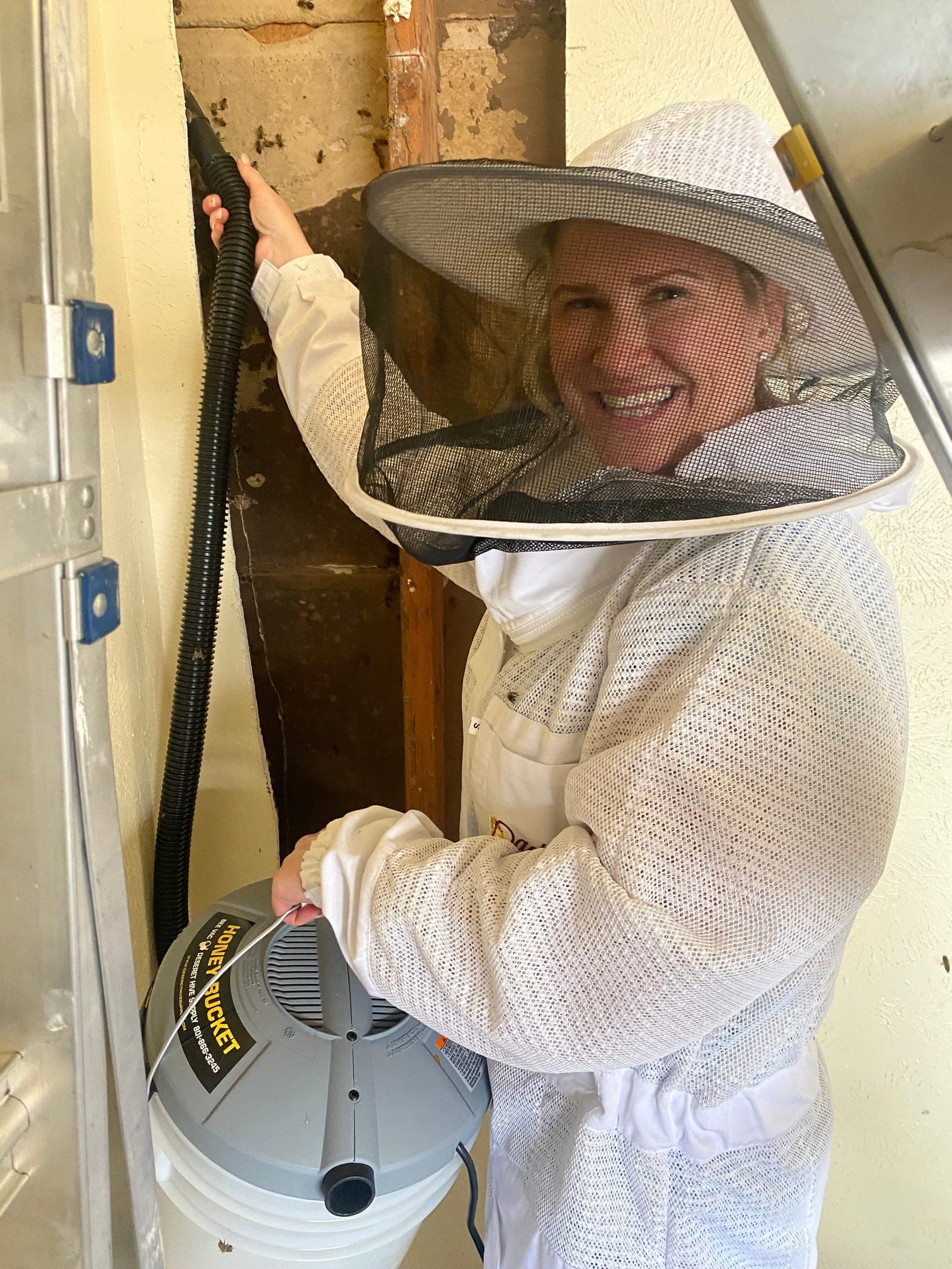 Esther Davis in a veil beside an opened wall during a removal